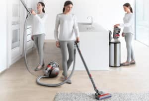 Una mujer utiliza un aspirador con cable o trineo Dyson